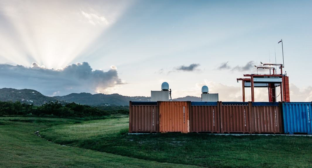 Storage containers and balloon launcher in a field.
